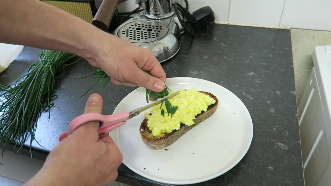 Soft scrambled eggs and chopped chives served on toast