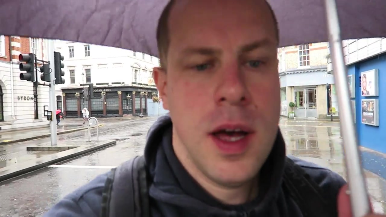 Barry under an umbrella on a rainy Chelsea street after breakfast