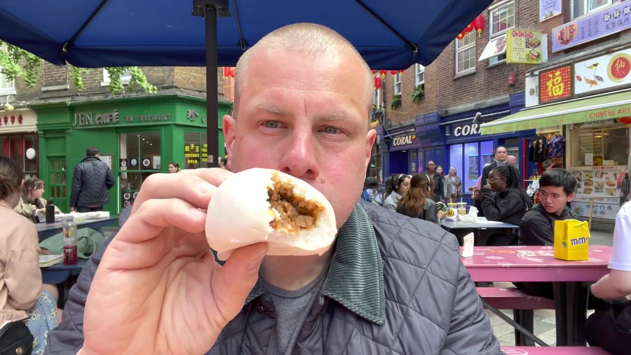 A steamed pork bun from Bun House opened to show its char siu-style filling.