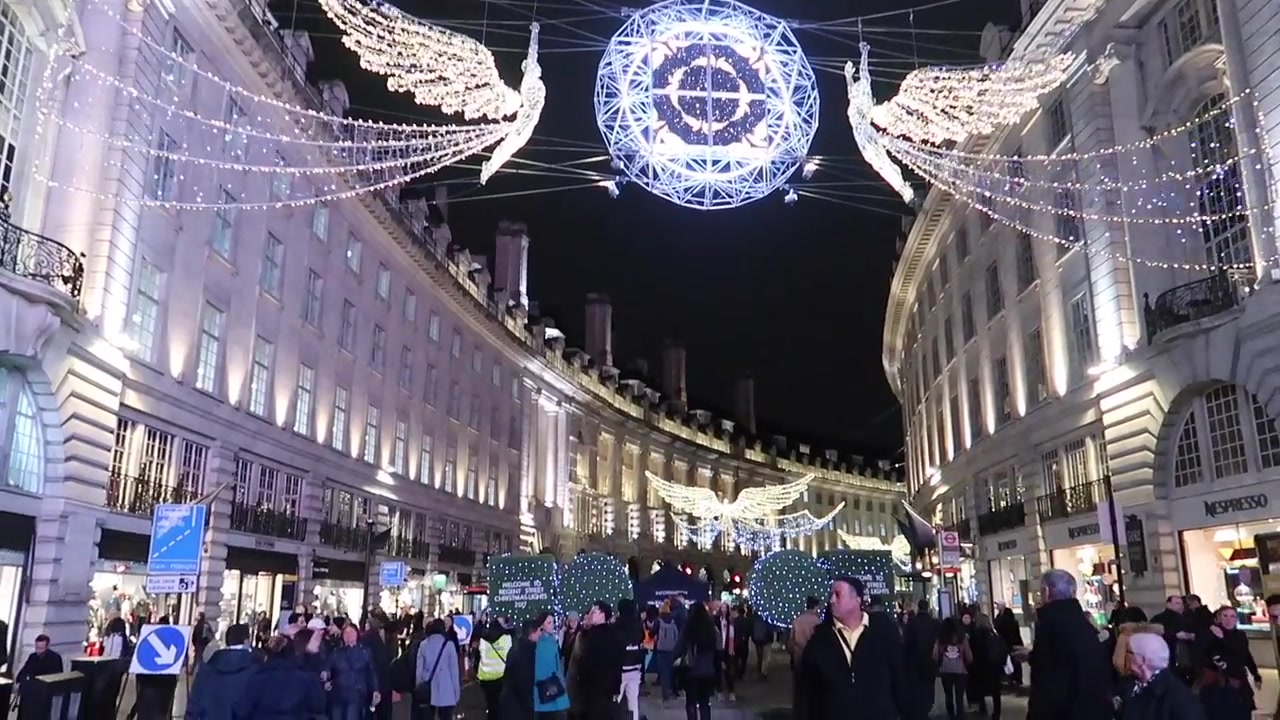 Crowds walking beneath Regent Street Christmas lights in central London
