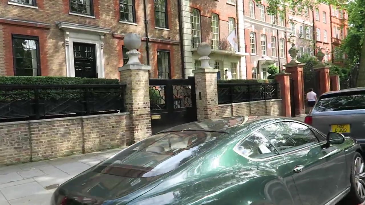 Historic red-brick Cheyne Walk house behind brick piers and iron gates