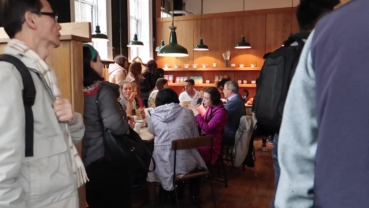 Customers gathered around the communal table inside Monmouth Coffee
