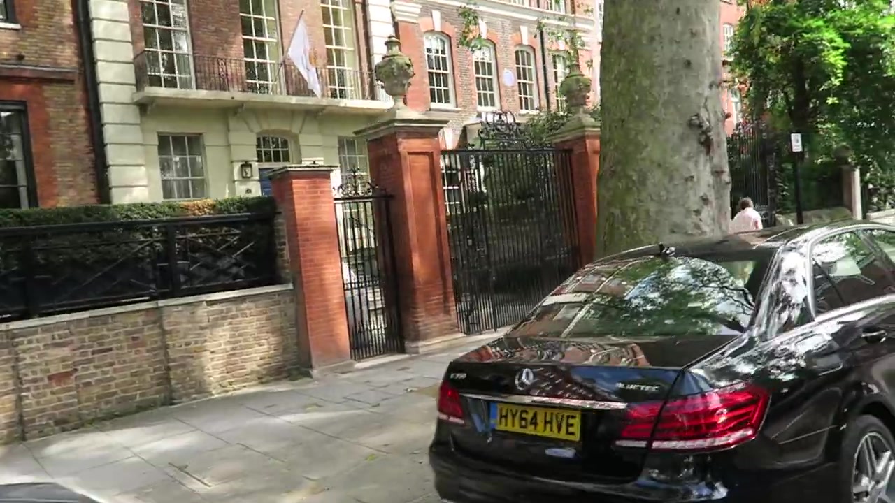 Red-brick Chelsea townhouse façade behind iron gates on Cheyne Walk