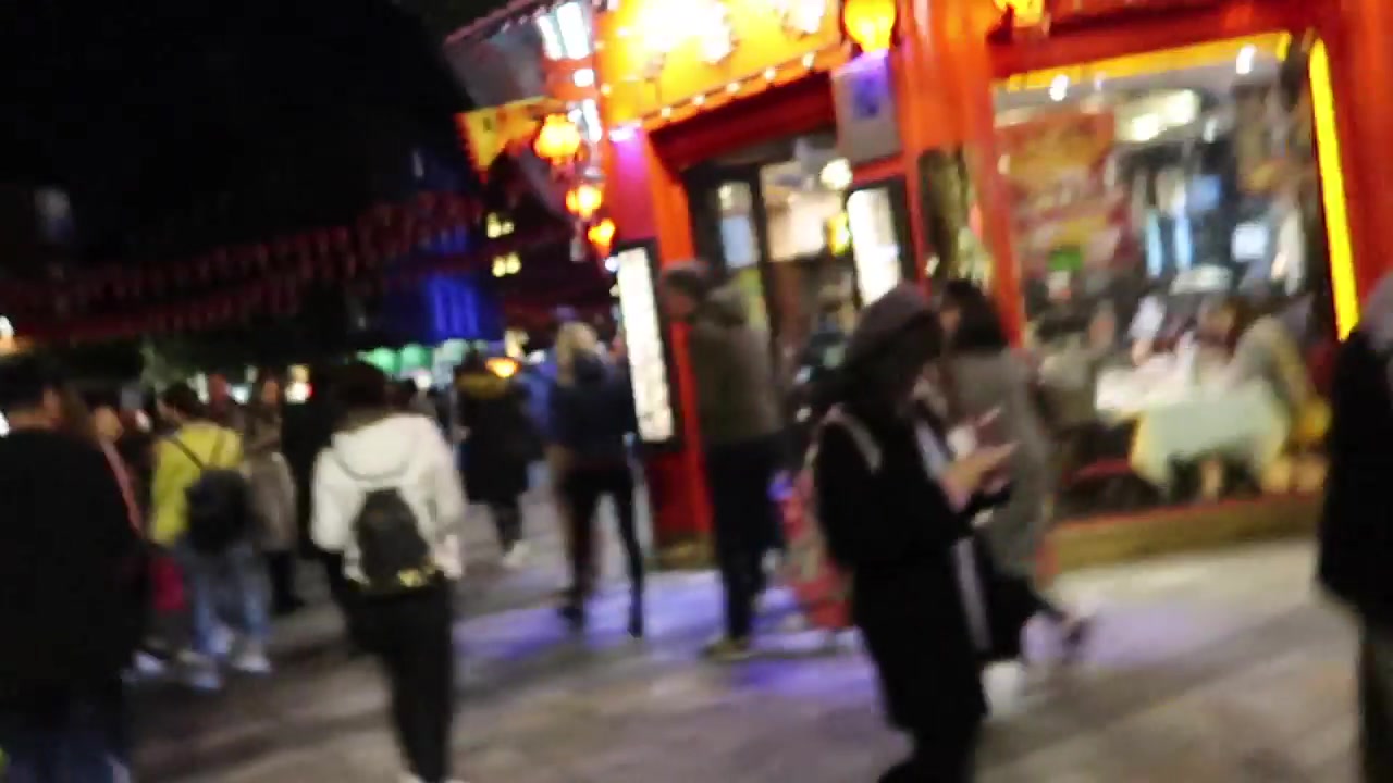 London Chinatown gate and restaurant frontage illuminated beneath red lanterns at night