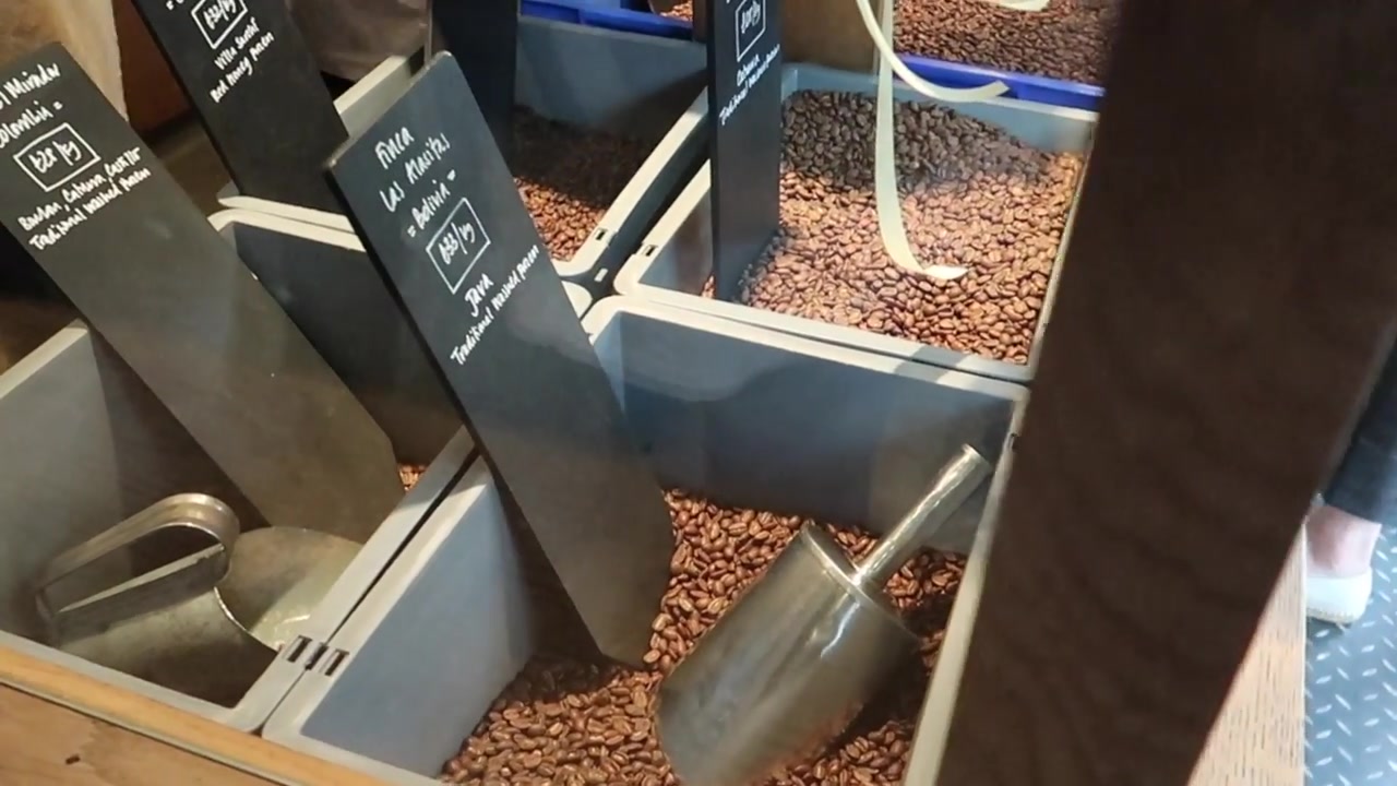 Roasted coffee beans displayed in labelled containers inside Monmouth Coffee
