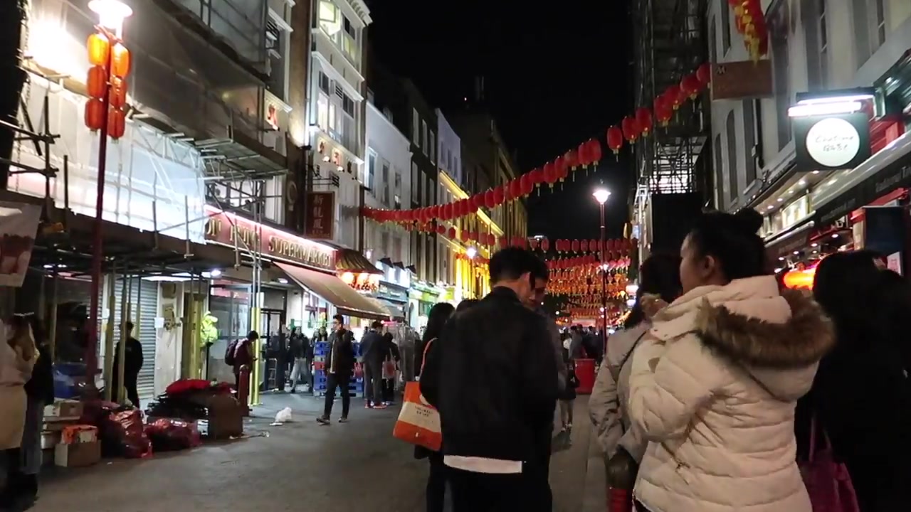 Cup of bubble tea with tapioca pearls held on a London Chinatown street at night