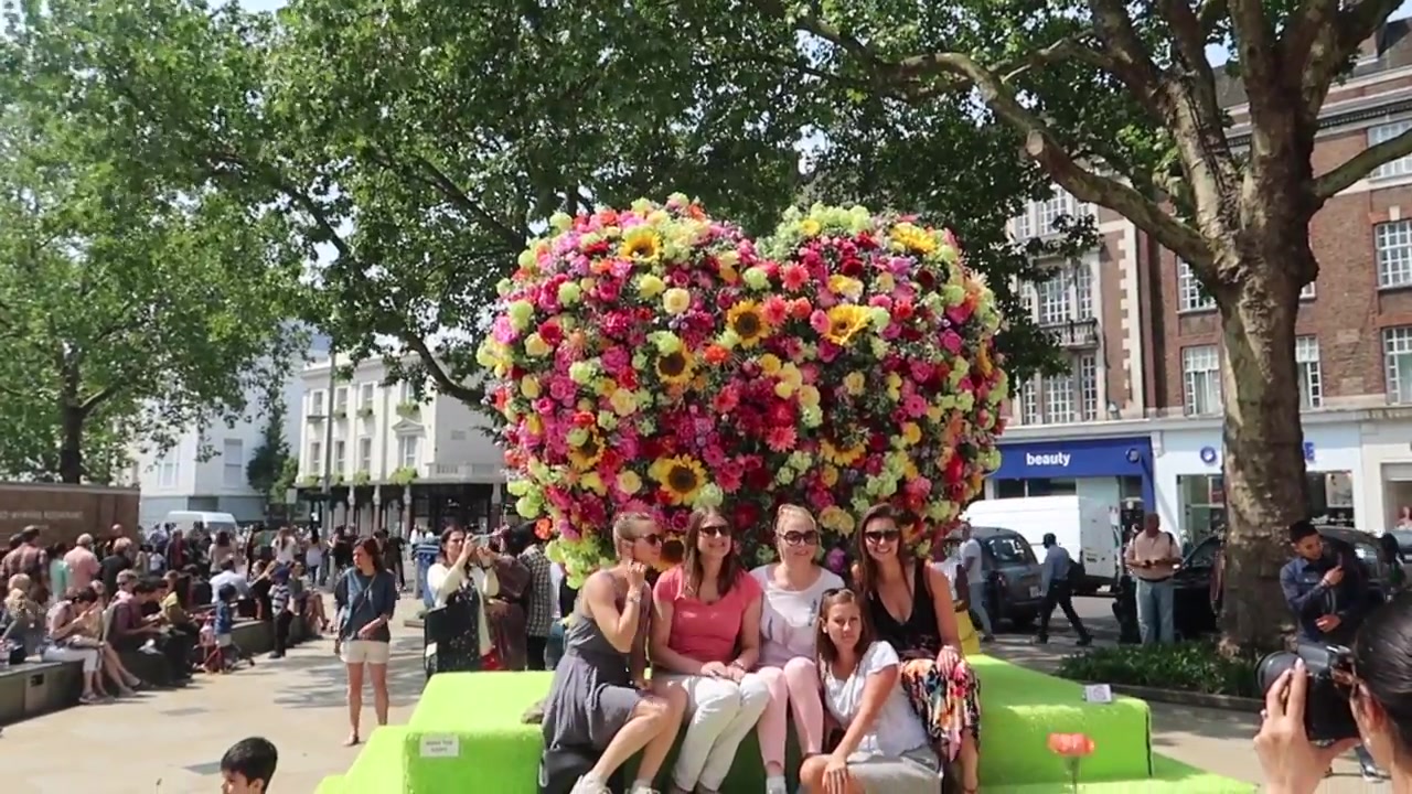 Large colourful floral display surrounded by visitors near Sloane Square, Chelsea