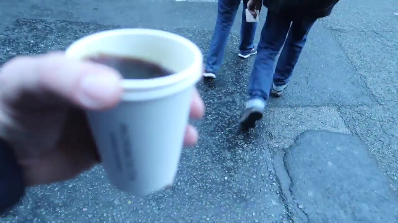 Cup of black takeaway coffee held outside at Borough Market
