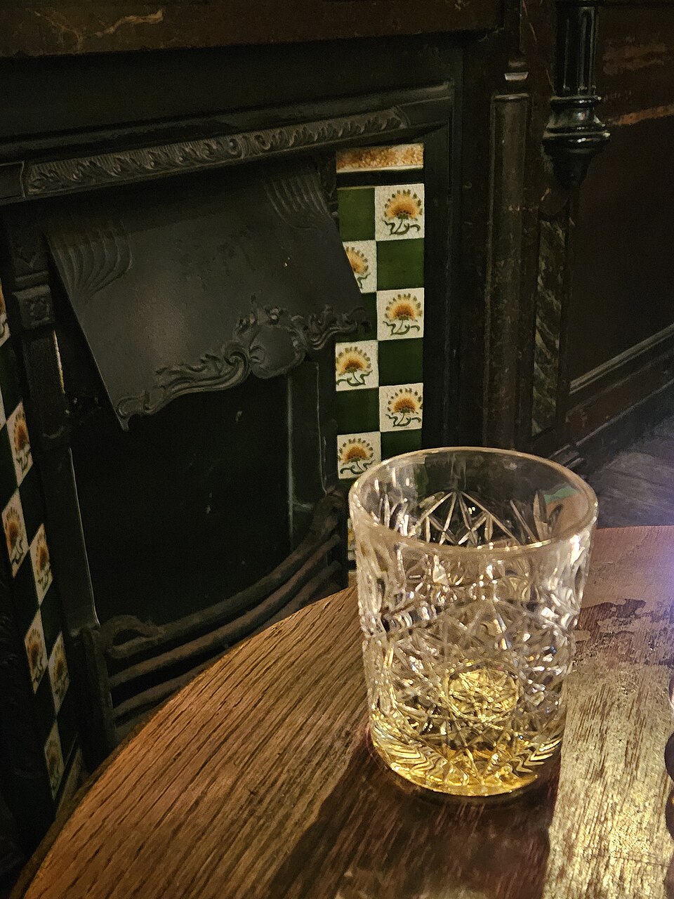A pint on the wooden bar beside the dark historic interior of the Nell Gwynne Tavern