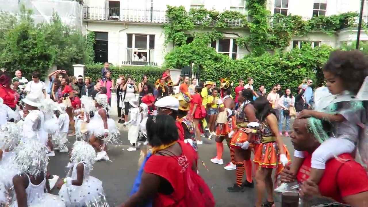 Dancers in coordinated red costumes performing at Notting Hill Carnival