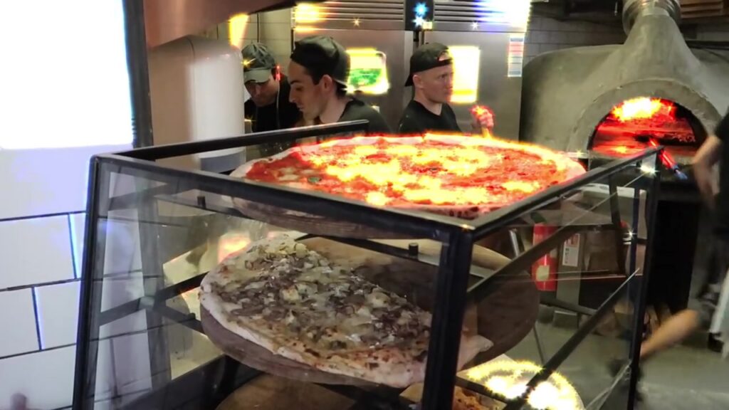 Large Homeslice pizzas beside the wood-fired oven in Neal's Yard in 2018