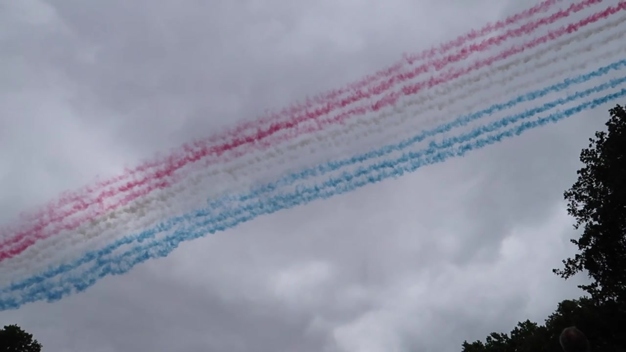 Red Arrows trailing red, white and blue smoke during the RAF100 flypast over London