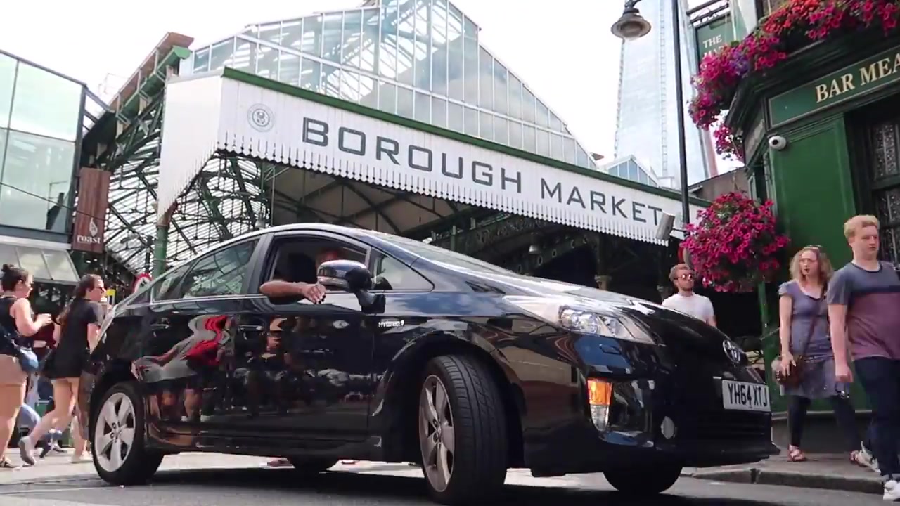 Shoppers beneath the Borough Market entrance sign.