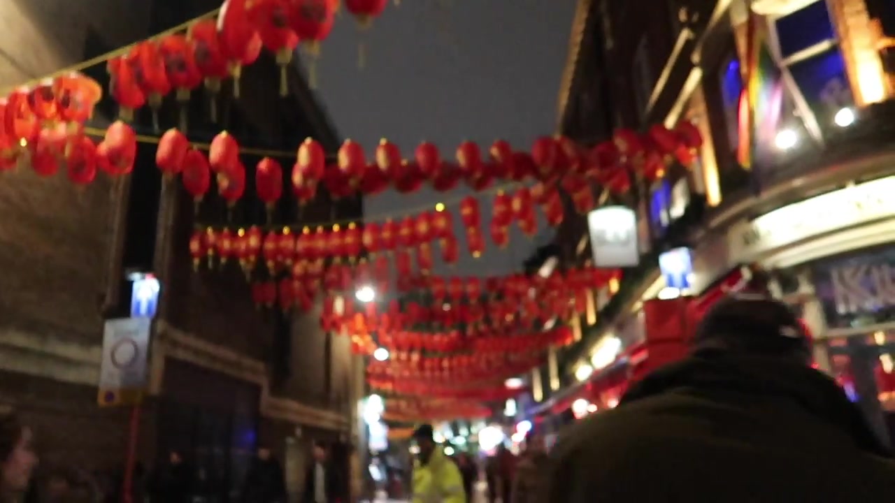 Red lanterns above a Chinatown street at night.