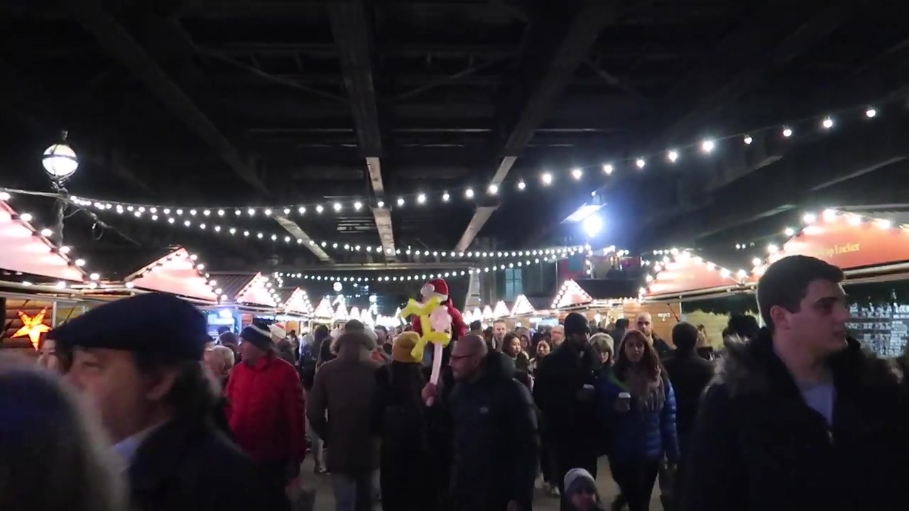 Visitors among the wooden chalets and festive lights on the South Bank.