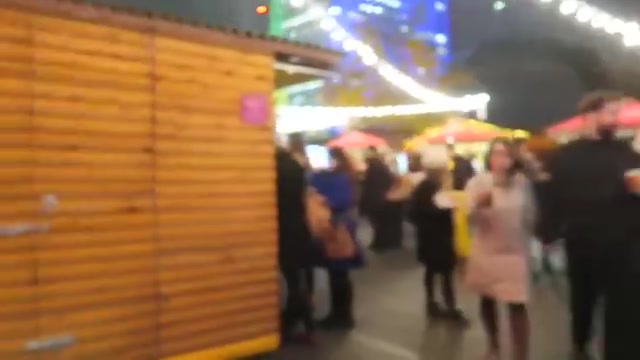 Visitors walking between Christmas market chalets on London’s South Bank
