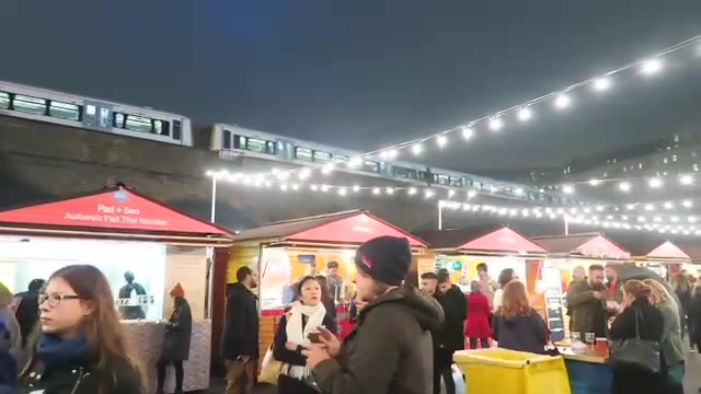 Crowds at the Southbank Christmas Market beneath strings of lights in 2016