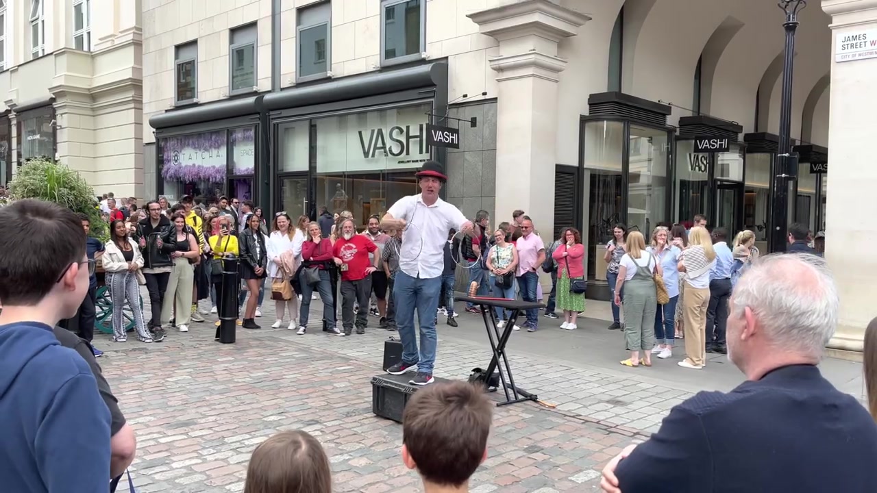 Audience watching a Covent Garden street performance in 2022