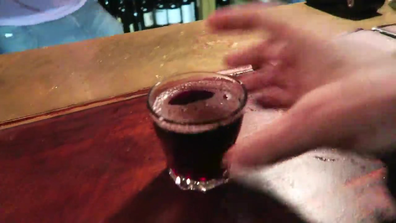 Small glass of red wine on the wooden counter at Gordon’s Wine Bar