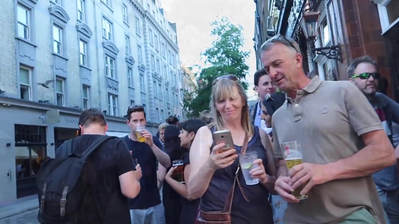 People drinking outside The Crown pub in Seven Dials on a summer evening