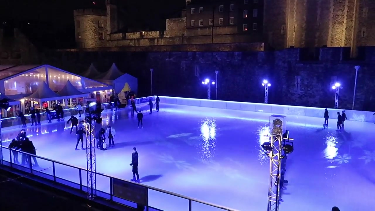 Skaters on the ice rink beside the Tower of London.