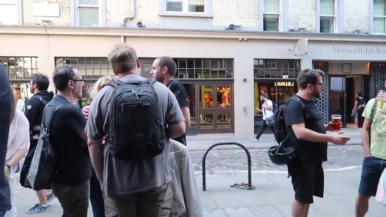 People walking through Seven Dials towards Neal's Yard on a summer evening