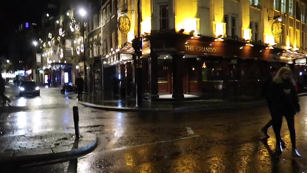 The illuminated exterior of the Chandos pub on a wet evening.