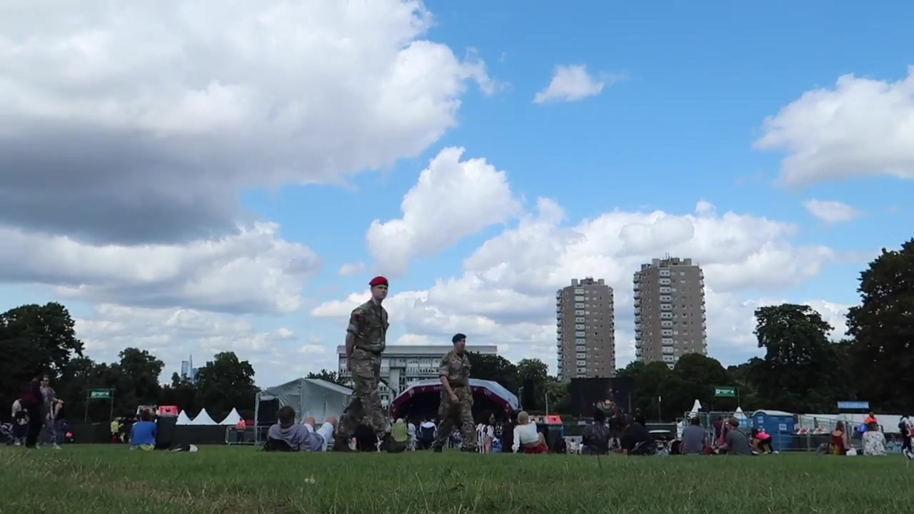 Visitors and festival structures beneath a summer sky.