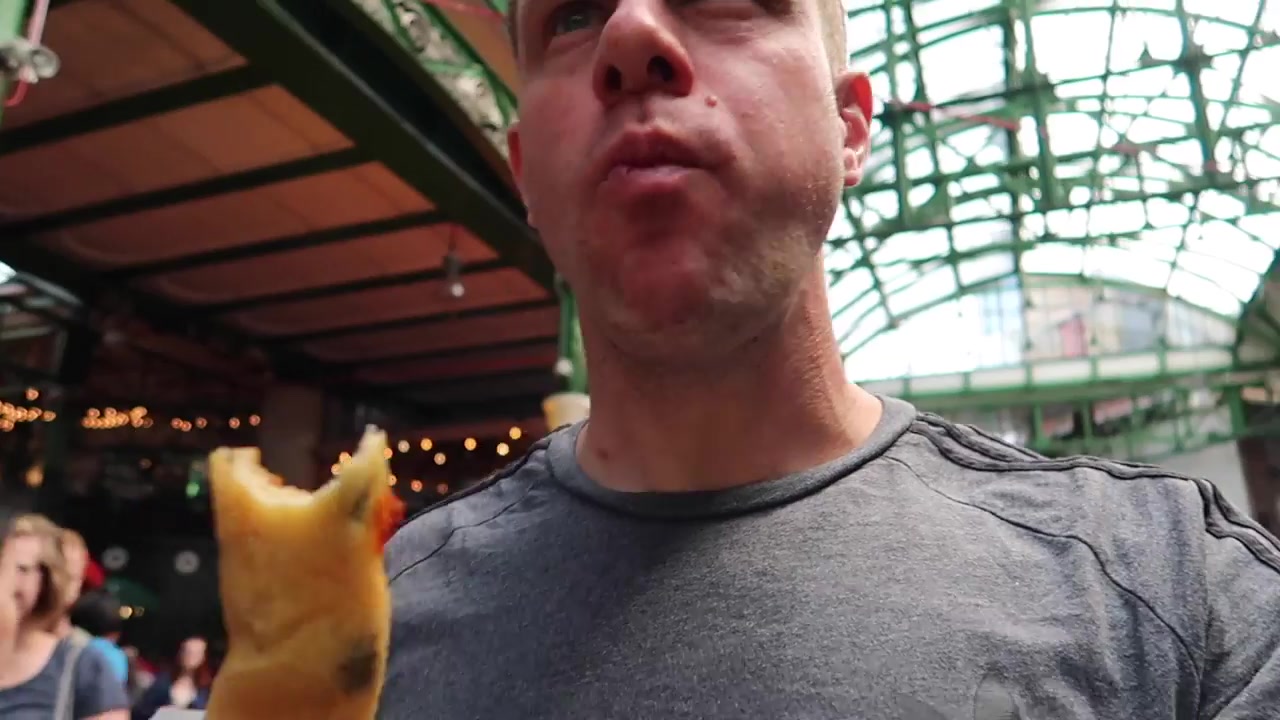 Barry with his Bread Ahead breadstick beneath the market roof.