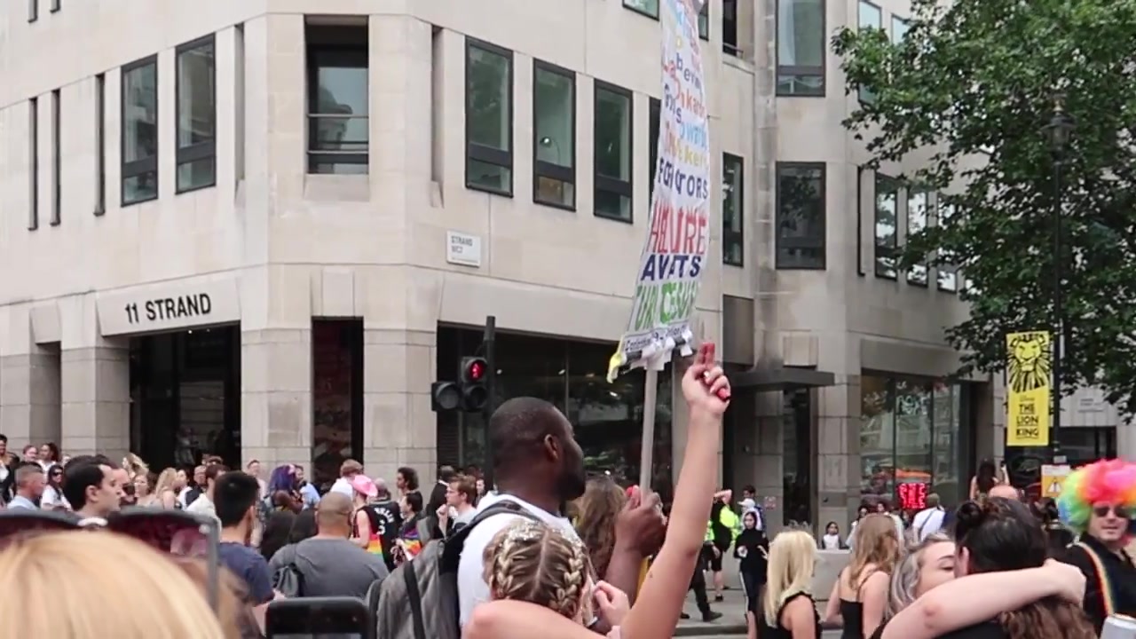 Spectators and placards along the Pride parade route.