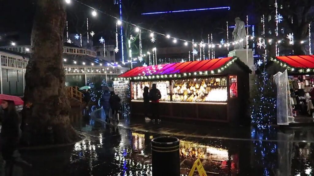 Christmas lights reflected on the wet paving at Leicester Square’s market.