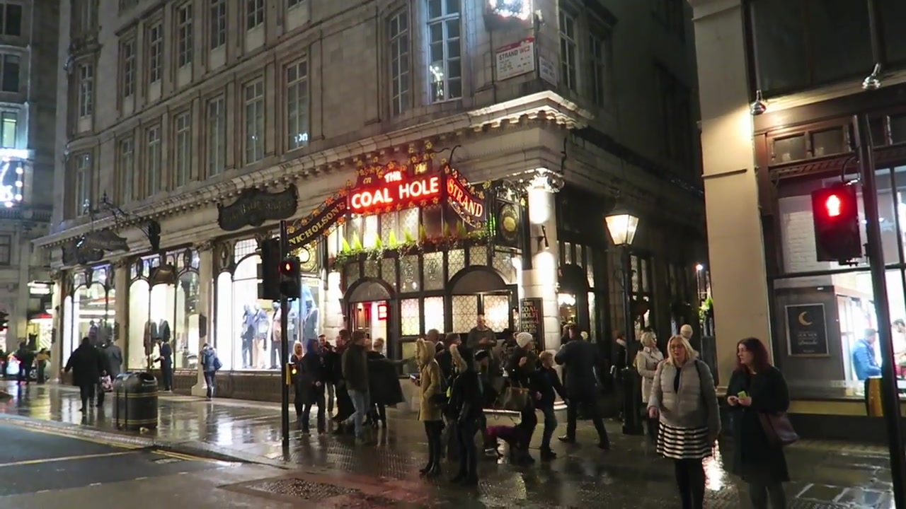 Illuminated exterior of the Coal Hole pub on the Strand on a rainy night