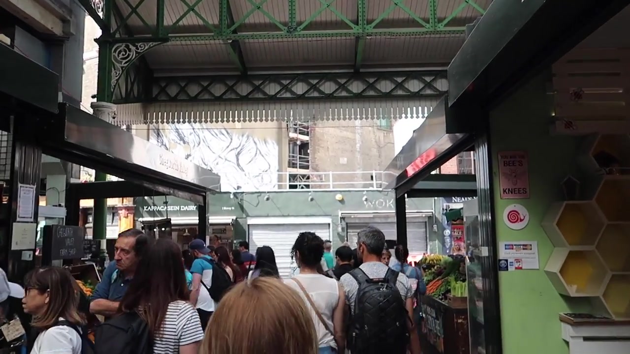 Shoppers beneath the green ironwork and glass roof at Borough Market.