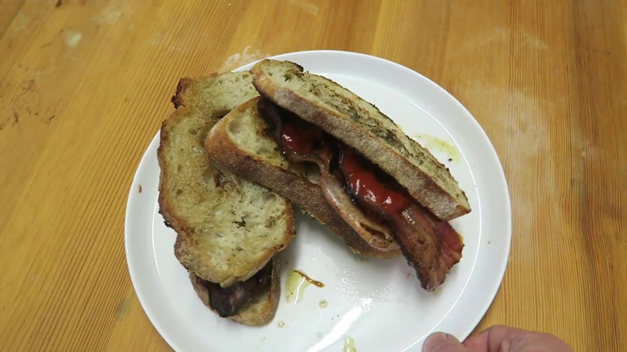 Finished double bacon sandwich on toasted rustic bread with tomato sauce