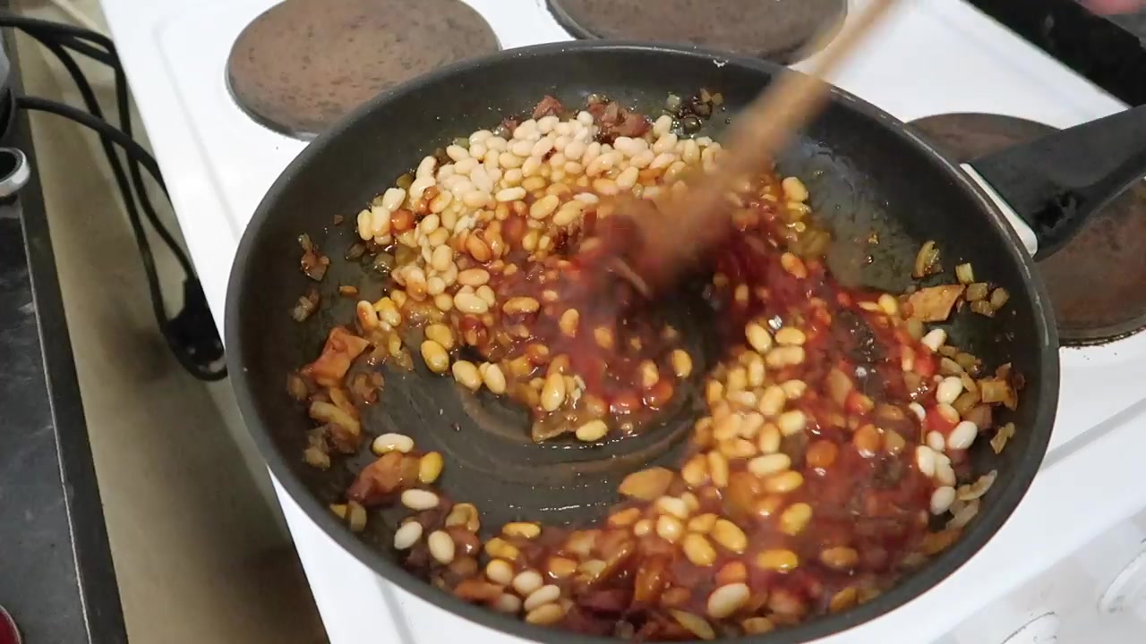 Homemade smoky baked beans simmering in a tomato sauce