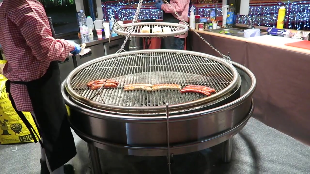 Bratwurst sausages cooking on a circular grill at the Southbank Christmas market