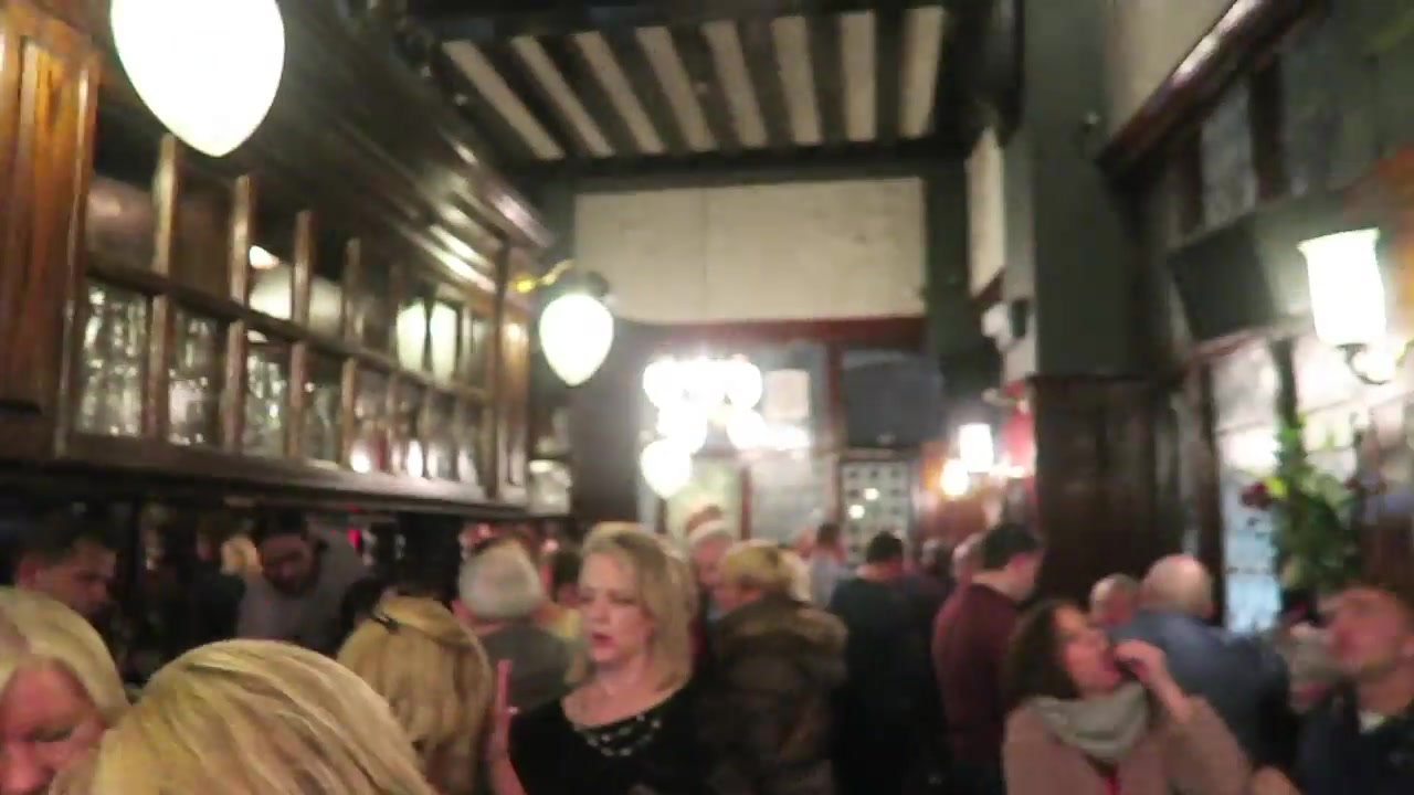 Crowded traditional interior of the Coal Hole pub on the Strand