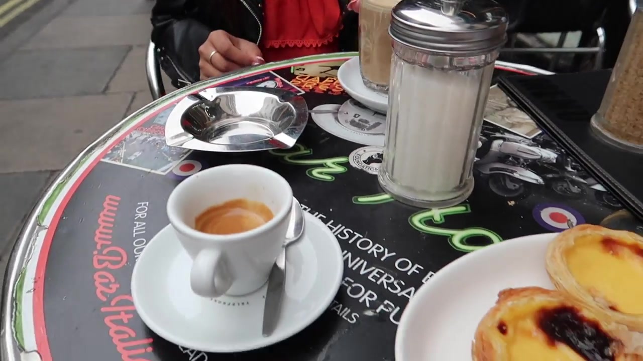 Espresso coffee and small pastries on an outside table at Bar Italia in Soho