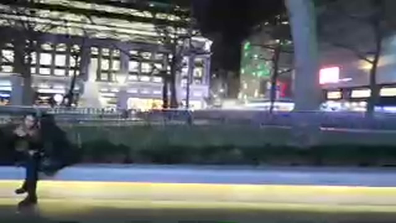 Leicester Square illuminated at night with visitors and large outdoor screens in February 2017