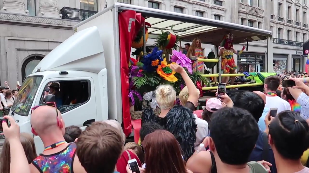 A parade float decorated with large colourful flowers.