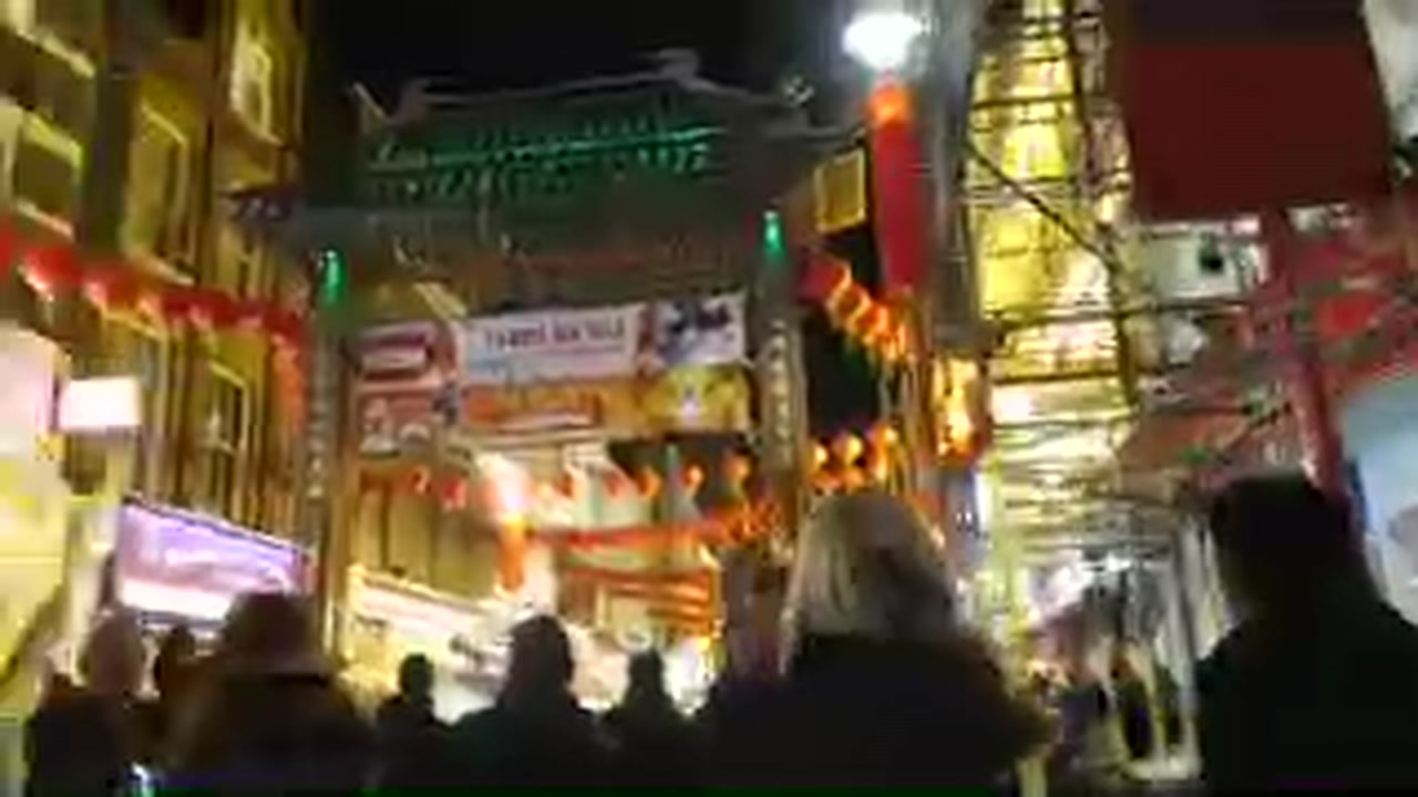 Crowds walking beneath red lanterns in London’s Chinatown during Chinese New Year season 2017