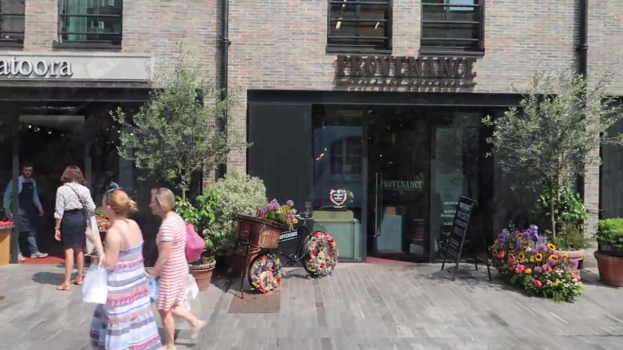 Flower displays and decorated bicycle outside shops in Duke of York Square