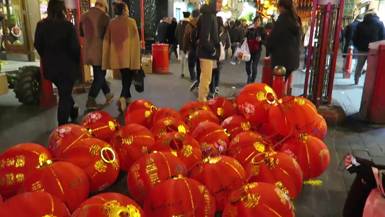 London Chinatown street glowing beneath rows of red lanterns after dark