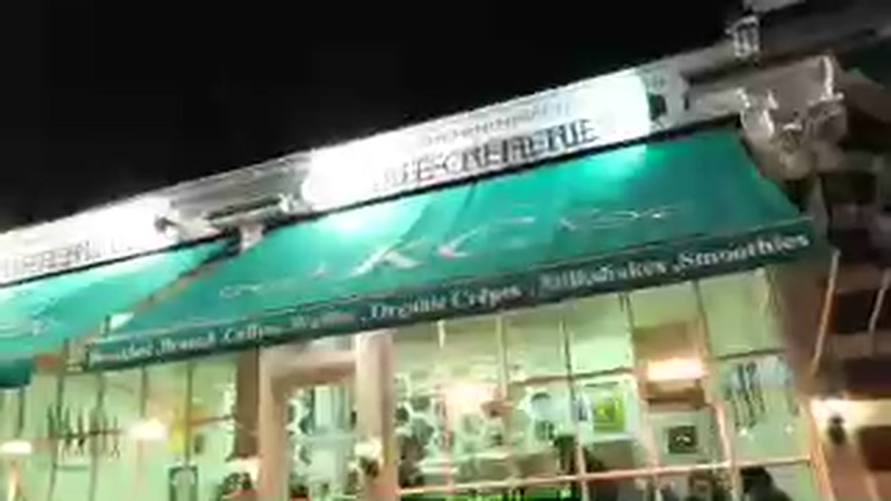 Green awning of Kensington Creperie on Exhibition Road at night in February 2017