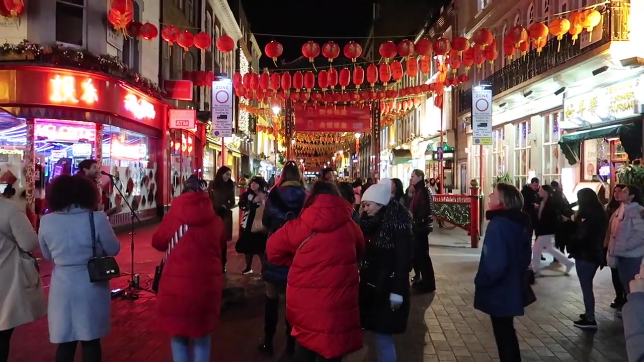 Busy London Chinatown street beneath red lanterns