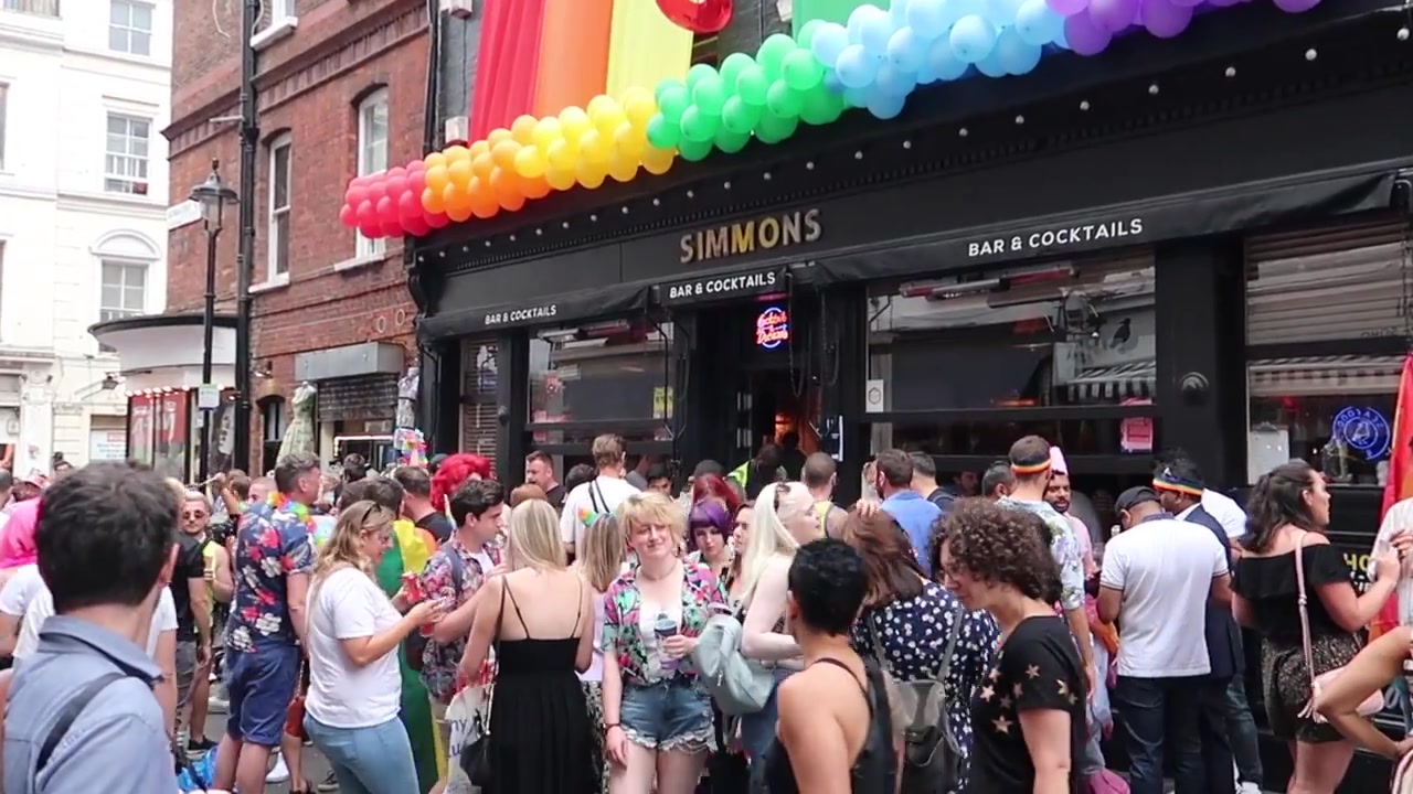 Rainbow balloons above a shopfront during Pride.