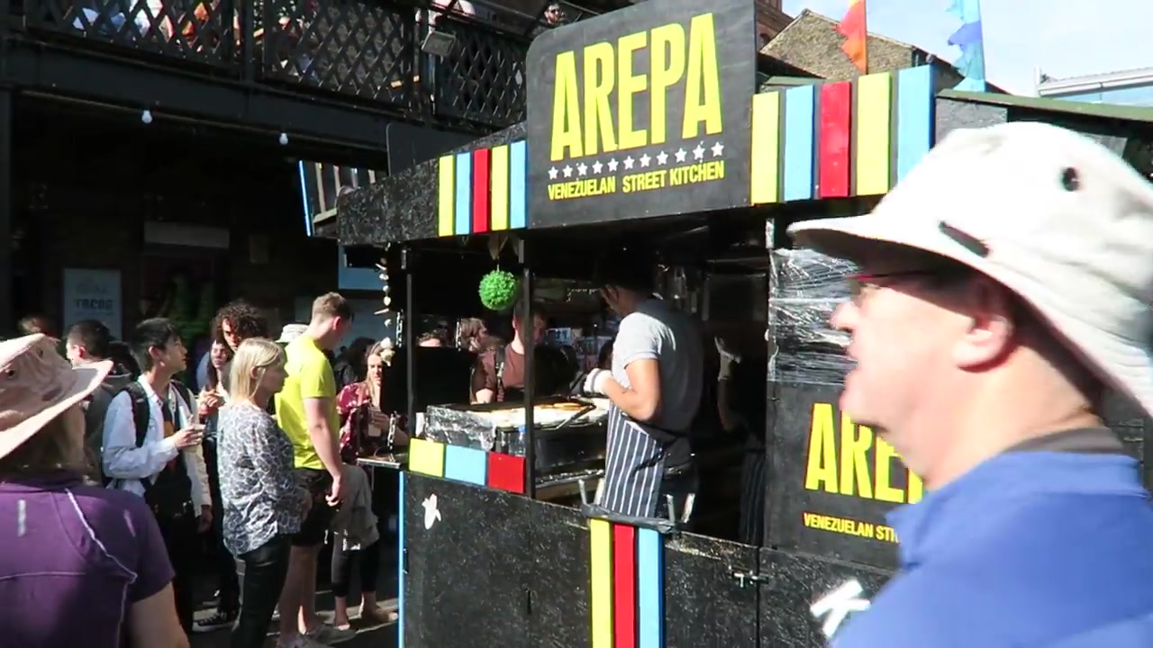 Arepazo Bros arepa stall with colourful sign and customers at Camden Market