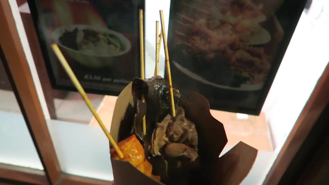 Open takeaway carton holding five Baozi Inn skewers in Chinatown