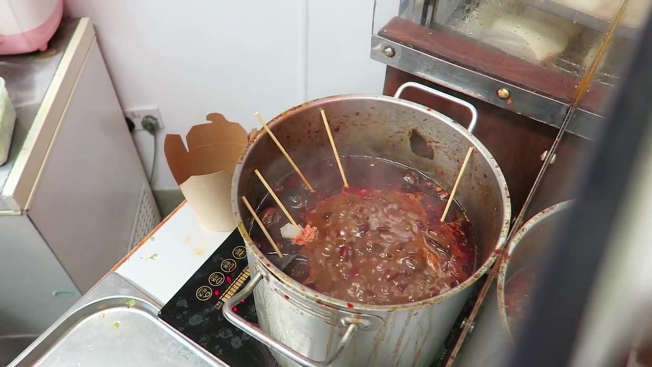 Skewers in a pot of spicy cooking liquid at Baozi Inn Chinatown