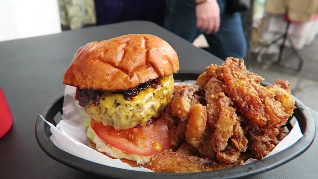 Burger and crisp plantain strips served together on a tray